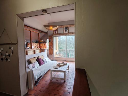 ein Wohnzimmer mit Sofa und Tisch in der Unterkunft Maison à 5mn de Honfleur in Fourneville