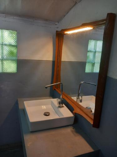 ein Badezimmer mit Waschbecken und Spiegel in der Unterkunft Avalon Villa Unawatuna in Unawatuna