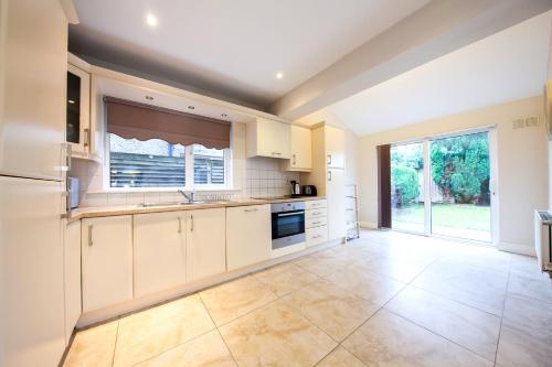 een keuken met witte kasten en een groot raam bij Modern 3BDR property in beautiful Swords Dublin in Swords