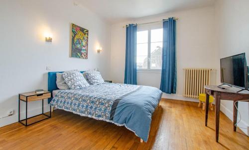 ein Schlafzimmer mit Bett, Schreibtisch und Fernseher in der Unterkunft Le chaource in Chaource