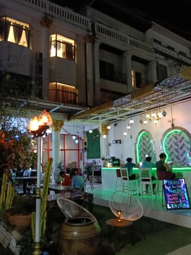 a group of people sitting at a restaurant at night at MaHaNa Hostel Pattaya in Jomtien Beach