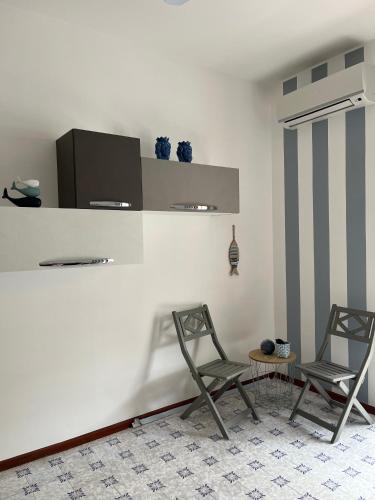 twee stoelen en een tafel in een kamer bij VitaDaMare in Giardini Naxos