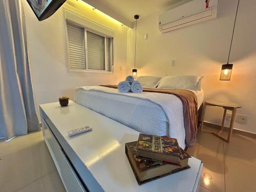 a bedroom with a bed and a table with two shoes on it at Studio Via Alameda- Próximo ao Aeroporto de Guarulhos in Guarulhos