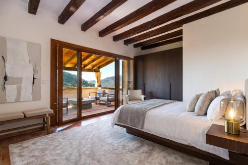 ein Schlafzimmer mit einem großen Bett und einem Balkon in der Unterkunft Villa My Love Mallorca in Bunyola