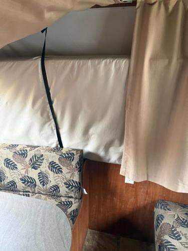 een bed met een kussen en een gordijn ervoor bij Ver-El RV Park & Campground in Concord