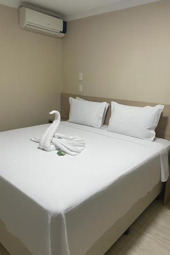a white bed with a white swan on it at Cristal park flats in Cristalina