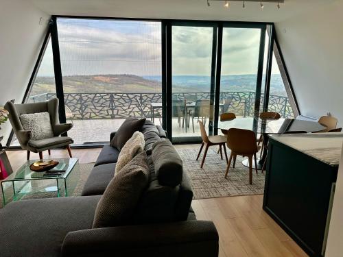 een woonkamer met een bank en een groot raam bij Wine Valley Villas in Lipovac