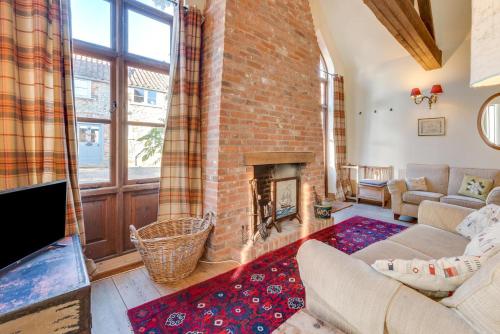 ein Wohnzimmer mit einer Ziegelwand und einem Kamin in der Unterkunft 1 Bed in Docking oc-670 in Docking