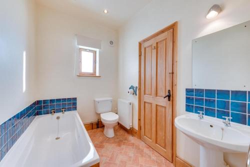 ein Badezimmer mit Badewanne, Toilette und Waschbecken in der Unterkunft 1 Bed in Docking oc-670 in Docking