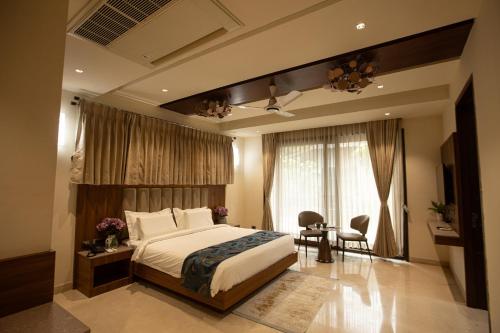 ein Schlafzimmer mit einem Bett, einem Tisch und Stühlen in der Unterkunft Rosse Dale Suites and Hotel Coimbatore in Coimbatore