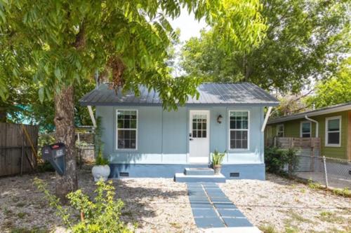a small blue house with a tree in the yard at Award winning Cultural Heritage home -Walk to Lake, La BBQ & Eateries in Austin