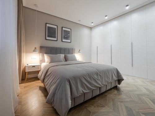 a bedroom with a large bed and a white wall at Arhitect INN in Sibiu