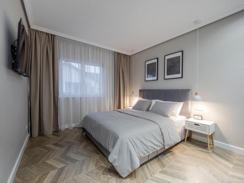 een slaapkamer met een groot bed en een raam bij ArhitectINN Sibiu in Sibiu