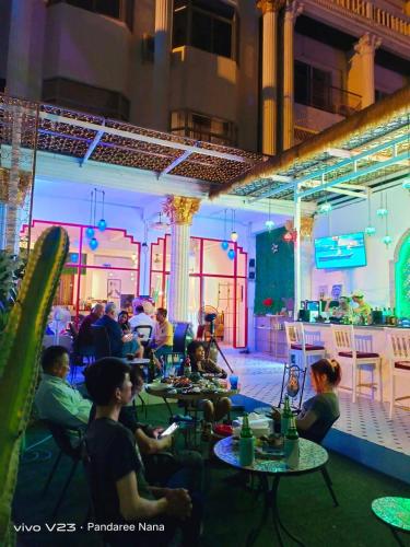 a group of people sitting at tables in a restaurant at MaHaNa Hostel Pattaya in Jomtien Beach
