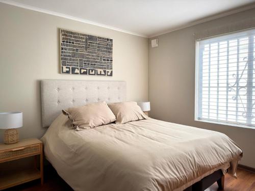 a bedroom with a white bed with two pillows at Arden Haus Estadías boutique Talca in Talca