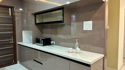 une cuisine avec un comptoir avec un grille-pain et un micro-ondes dans l'établissement Novo Stays - Artistic Boho Edition, à Hyderabad