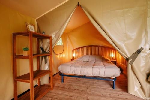 ein Schlafzimmer mit einem Bett in einem Zelt in der Unterkunft Camping 4 étoiles - Parc aquatique - ccbcbhg in Caro