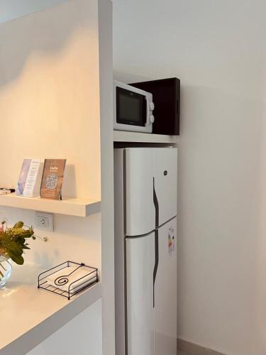 einen Kühlschrank mit einer Mikrowelle darüber in der Unterkunft Departamento Sofia Soberana in Bahía Blanca