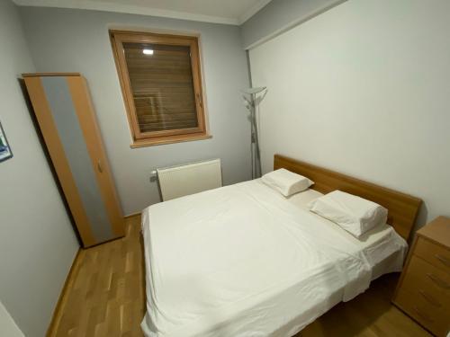 a bedroom with a white bed and a window at Bjelašnica Babin do Apartman in SJJ