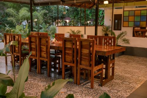ein Esszimmer mit einem Holztisch und Stühlen in der Unterkunft Ayurprana Marari in Mararikulam