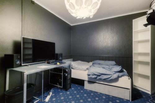 斯彻达尔Room Trondheim Airport的一间带书桌的卧室和一张带电脑的床