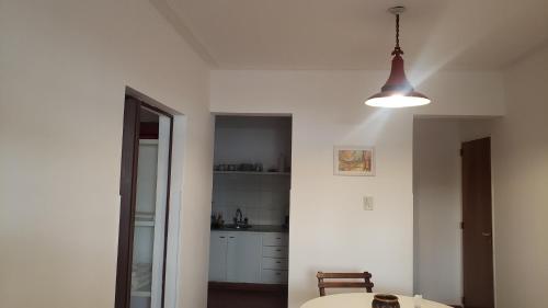 una cucina bianca con un tavolo e una luce di Urban 360 a Río Cuarto