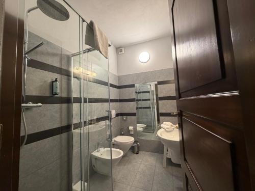 a bathroom with two toilets and a glass shower at Locanda Dell' Orso Bevitore in Verduno