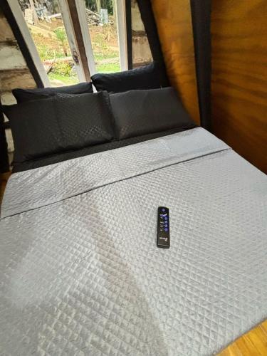 a bed in a van with a remote control on it at Recanto - Chalé Boa Vista in Jaraguá do Sul