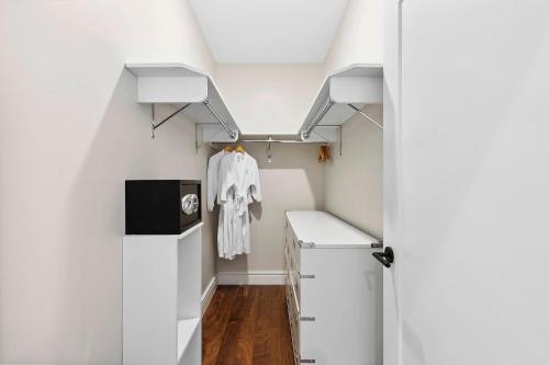 a small kitchen with white walls and white cabinets at Hotel Suites at Vanderbilt in Westbury