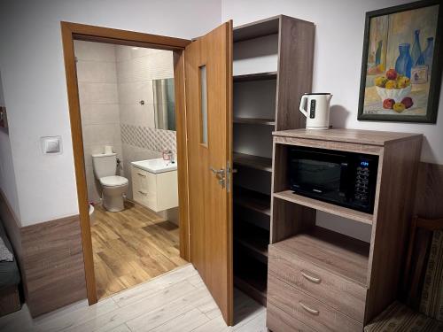 un piccolo bagno con servizi igienici e forno a microonde di Hostel Sportowa a Płońsk