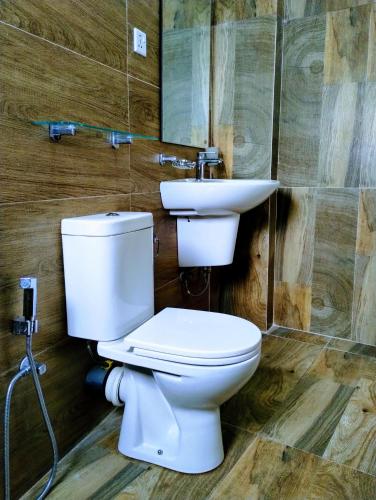 a bathroom with a white toilet and a sink at New Pensive Villa in Nuwara Eliya