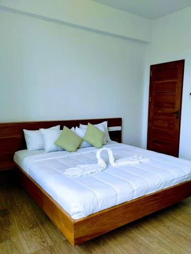 a bedroom with a large bed with white sheets at New Pensive Villa in Nuwara Eliya