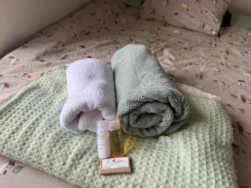 a bed with towels and a bottle of soap at Hacienda Esmeralda in Ñuñoa