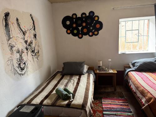 a room with two beds and a clock on the wall at Hacienda Esmeralda in Ñuñoa