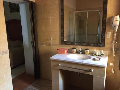 a bathroom with a sink and a mirror at La Casona Minera in Mineral de Pozos