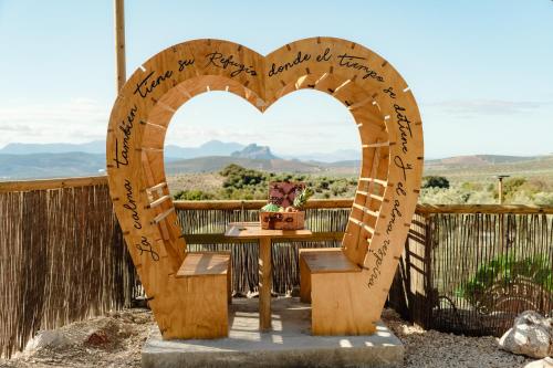 een hartvormige boog met een tafel met uitzicht bij Glamping El Refugio in Archidona