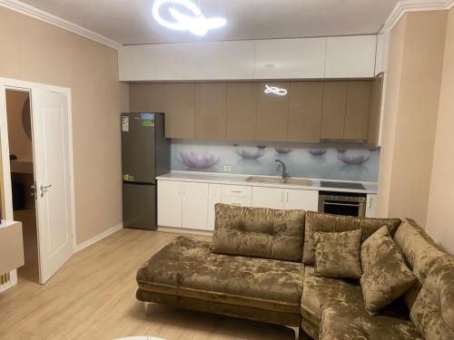 een woonkamer met een bank en een keuken bij Cherry Apartments in Shkodër