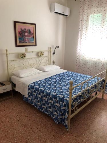 a bedroom with a bed with a blue and white blanket at BED AND BREAKFAST da Geanina è Rocco - LOCANDA YANIS in Mesola