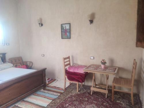 una camera da letto con un letto, un tavolo e delle sedie di إيتران - Itran a Siwa
