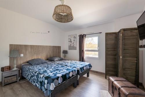 a bedroom with a bed and a large window at L'air de Riez in Saint-Hilaire-de-Riez