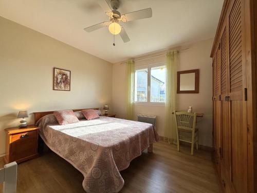 una camera da letto con un letto e un ventilatore a soffitto di L'oree du bois a Livron