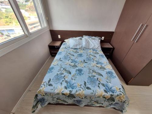 una piccola camera da letto con un letto con una coperta blu di LK Estoril 3 a Belo Horizonte