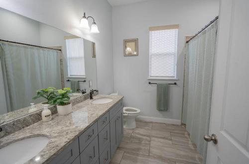 a bathroom with two sinks and a shower and a toilet at Pondfront Ranch • Theater Room • Sleeps 8 in Eagle Lake