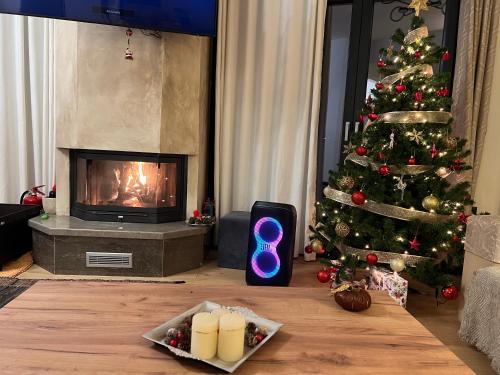 a living room with a christmas tree and a fireplace at Villa Harry Arachova in Kalívia