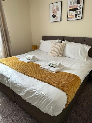 a bed with two towels on top of it at Yellow Sunflowers Flat In Stroud in Stroud