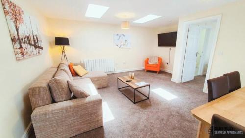 un soggiorno con un divano e un tavolo di White Jasmine in Stroud a Dudbridge