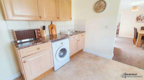 una cucina con lavello e lavatrice di White Jasmine in Stroud a Dudbridge