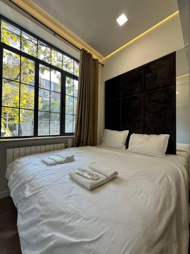 a white bed with two towels on top of it at Fairytale Apartment in Aghk'ilisa