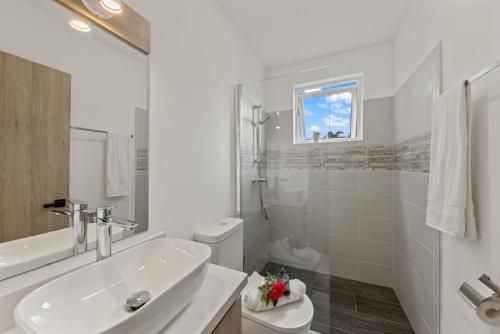 a white bathroom with a sink and a toilet at Apartement Ocean Hibiscus, Punta Azul Ocean Resort, Westpunt in Lagun