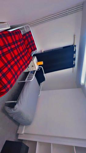 a closet with a red and blue blanket and a pillow at Flexy Students Room 1 in Gloucestershire